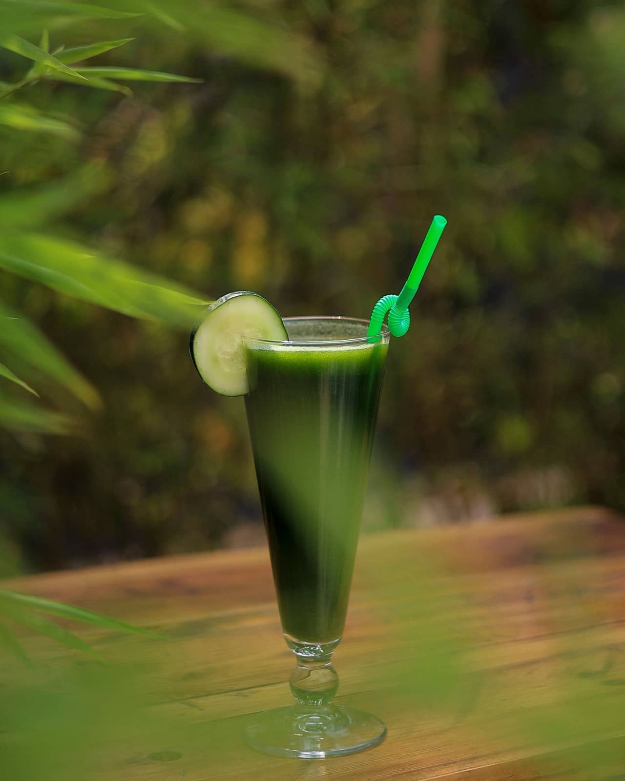 Green detox juice with a slice of cucumber