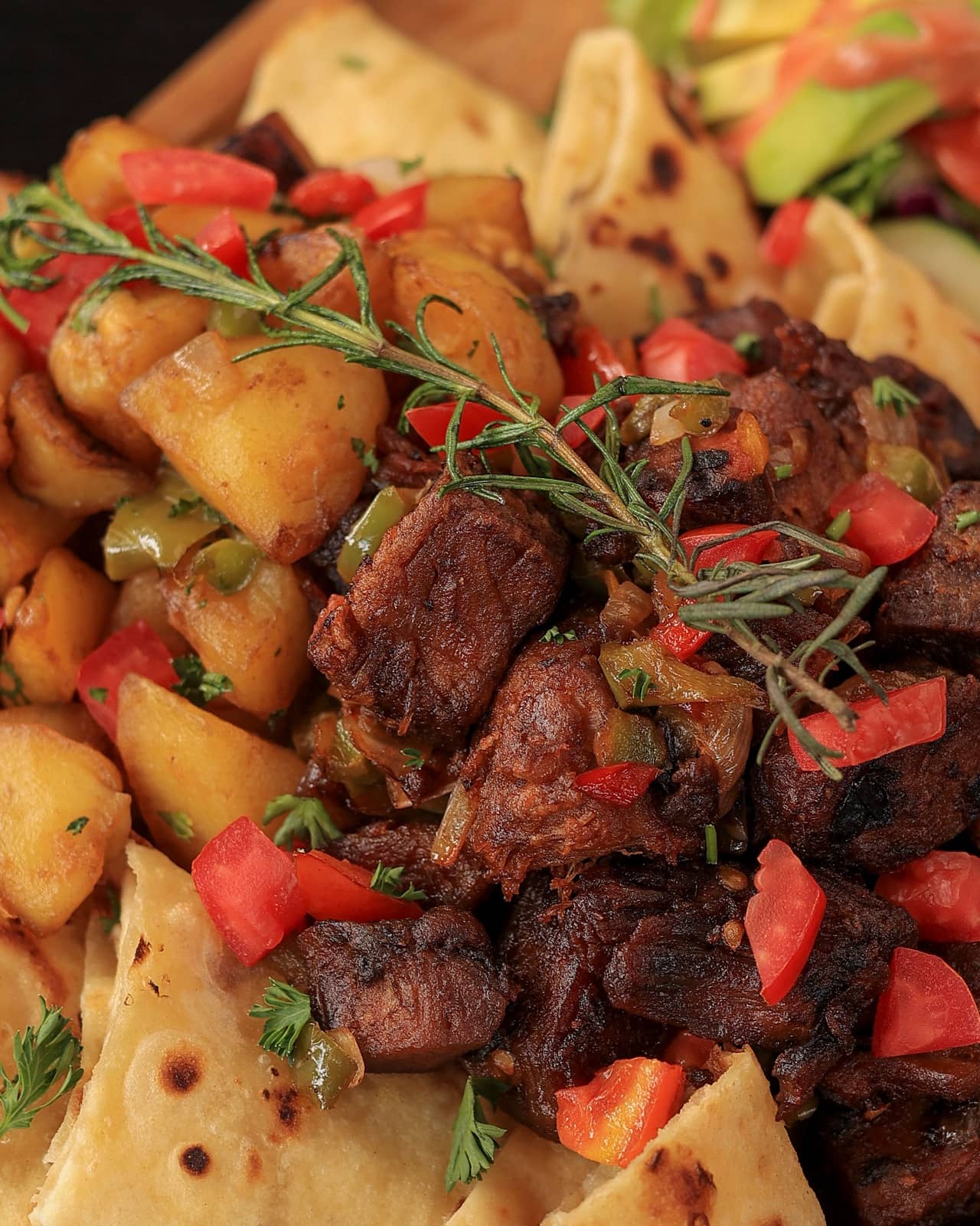Goat, potatoes and chapati on a wooden board