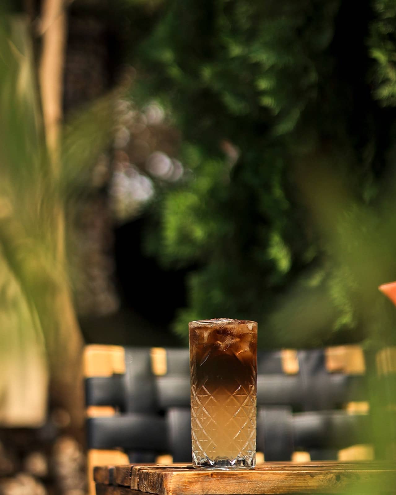 Layered iced coffee on a wooden terrace table