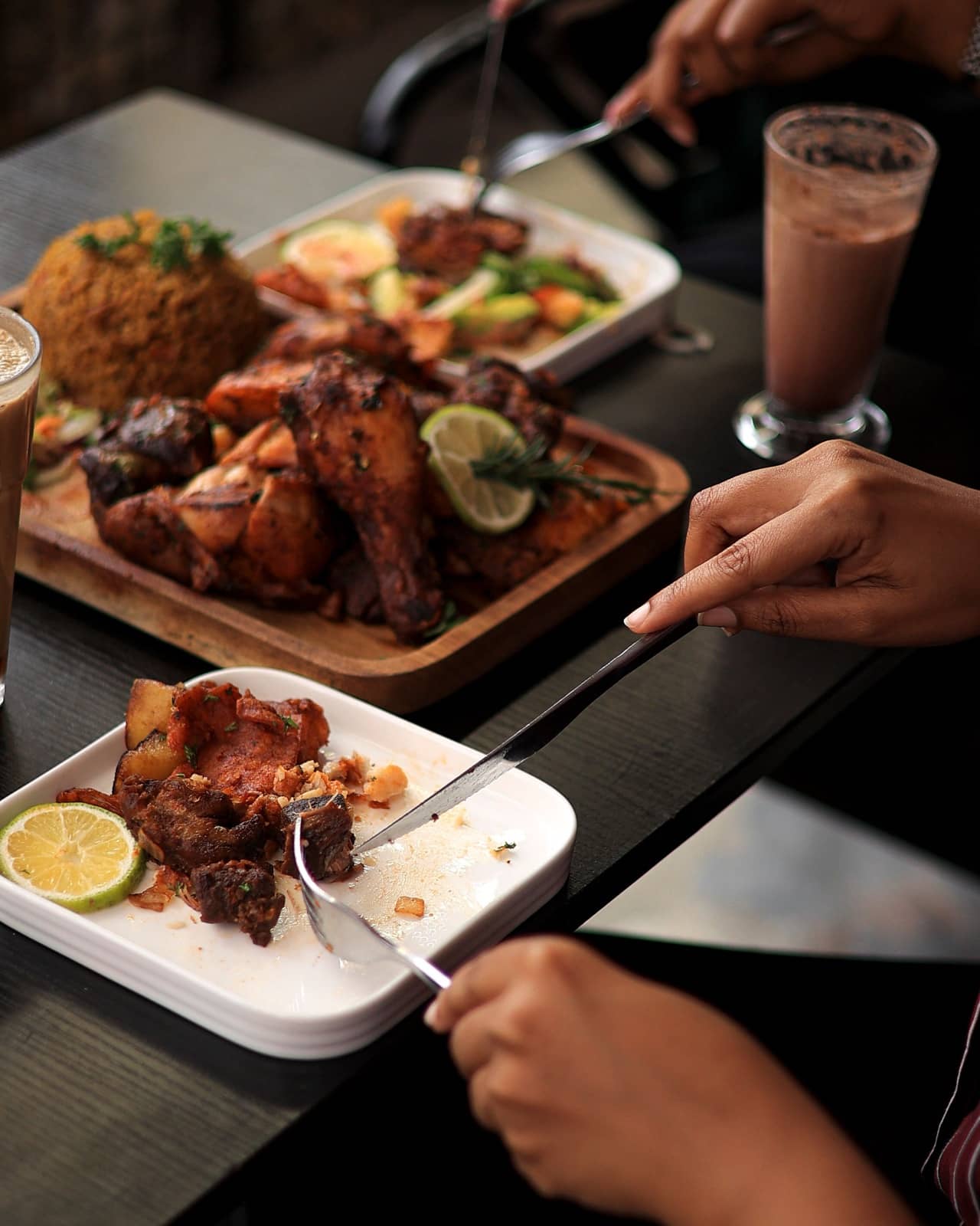 Friends sharing grilled chicken and jollof rice