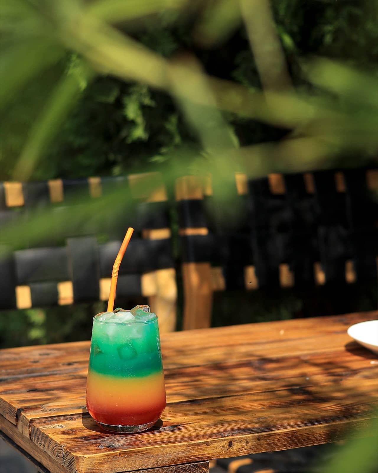 Layered green and red cocktail on a terrace table